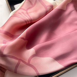 Detail of soft silk scarf with pink gradient floral pattern and elegant glossy texture