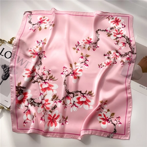 Detalle de un pañuelo de satén rosa con delicados motivos florales de magnolia