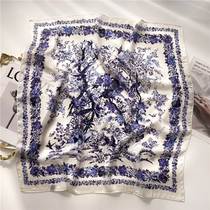 Detailed blue and white floral bird print on a silky square scarf with elegant draping