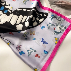 Texture détaillée d'un foulard en soie à imprimé papillon avec finition satinée
