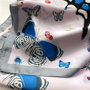 Détail de l'imprimé papillon et de la texture lisse sur ce foulard carré en soie