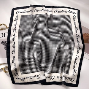 Elegant black and white houndstooth square silk scarf with lettered border flat lay
