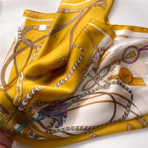 Close-up of silk scarf showing equestrian patterns and smooth satin texture
