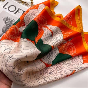 Detailed macro view of camellia floral pattern on smooth silk scarf with vibrant colors