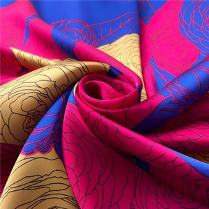 Detailed view of silk-like fabric with vibrant camellia floral prints and smooth texture