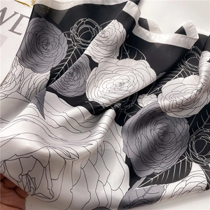 Detailed macro view of camellia flower pattern on smooth silk scarf with soft drape