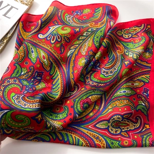Primer plano de pañuelo de seda rojo con motivos de cachemira y textura suave y lisa