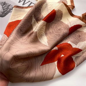 Close-up of elegant camellia floral silk scarf with smooth texture and delicate rolled edges