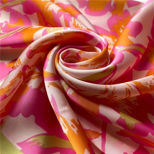 Primer plano macro de pañuelo de seda floral con textura satinada y colores vibrantes