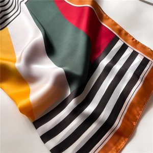 Detail view of colorful geometric striped silk scarf showing satin texture and fine stitching