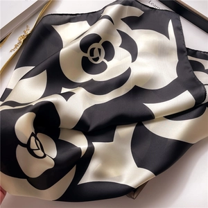 Close-up of silk satin camellia floral pattern square scarf with elegant glossy texture