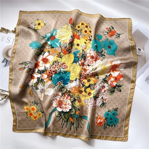 Close-up of floral silk scarf featuring vintage rose prints and monogram pattern detail