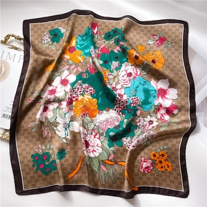 Macro detail of silk scarf showing vintage floral patterns and interlock geometric textures