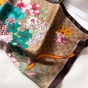 Detail of floral silk scarf with vintage botanical prints and luxury monogram pattern