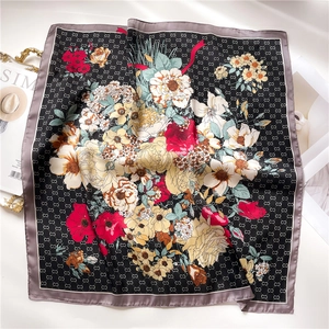 Detail of silk square scarf featuring interlocking C logo and vibrant floral pattern print