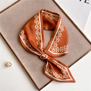 Detail of caramel silk scarf with white chain print on velvet display tray