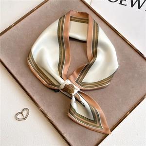 Detail of elegant silk scarf with vintage horse carriage patterns and geometric pink edges