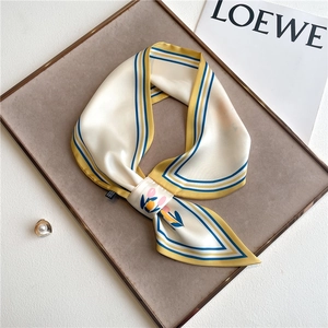 Detail of a chic cream silk-feel scarf with tulip print and contrast stripe borders