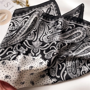 Close-up of black and white paisley pattern silk scarf with elegant polka dot details