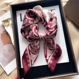 Deep burgundy paisley silk scarf tied in a bow knot inside a premium gift box