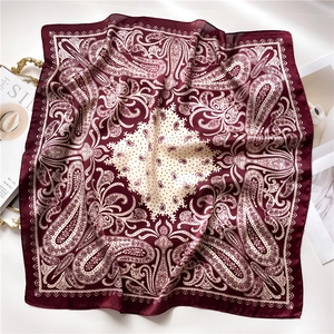 Detail of burgundy paisley silk scarf with vintage cashew floral prints on soft fabric