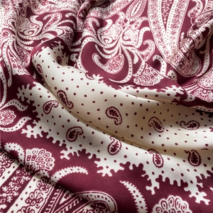 Macro shot of paisley silk scarf with burgundy and cream floral vintage pattern