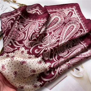 Detailed view of paisley silk scarf with burgundy patterns on elegant lifestyle background
