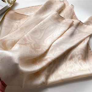 Detailed view of satin paisley scarf with elegant champagne silk texture and patterns