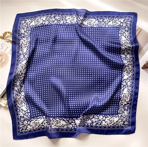 Detail of square silk scarf featuring navy blue rose floral prints and polka dot patterns