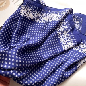 Detail of silk-like scarf showing navy blue vintage floral pattern and soft texture