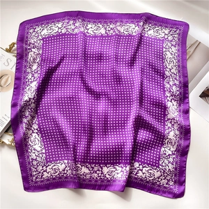 Detail of a purple square silk scarf with white rose patterns and polka dot prints