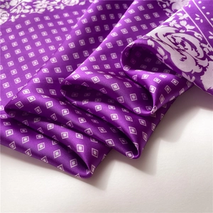 Close-up of purple satin scarf with white diamond pattern and floral border details