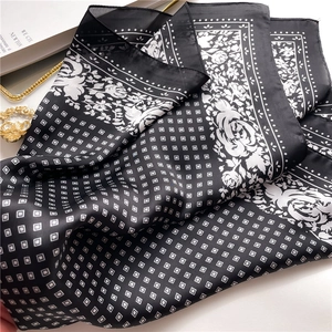 Detail of silk scarf showing rose patterns and soft fabric texture on a gold tray