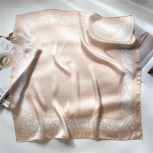 Close-up of champagne silk square scarf with white rose floral border and grid patterns