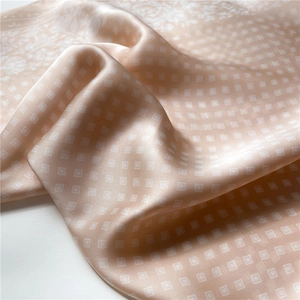 Close-up of champagne pink checkered silk scarf with soft drape and satin texture