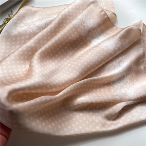 Detailed view of champagne satin scarf featuring checkered patterns and floral prints
