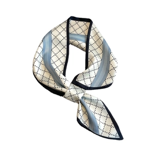 Elegant ivory faux silk skinny scarf with black diamond pattern in a tied bow style