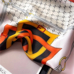 Détail d'un foulard en soie montrant des motifs de chaîne et une texture lisse