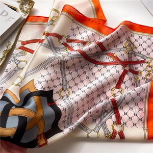 Vue détaillée du foulard en soie orange avec motifs équestres de harnais et de ceintures