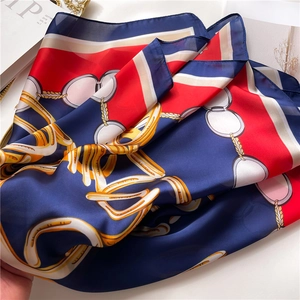 Detailed view of silk texture scarf with classic equestrian chain print in red and blue