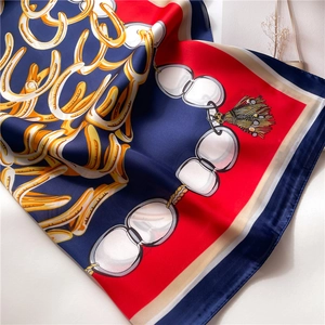 Close-up of silk-like square scarf featuring equestrian motifs with golden horseshoes
