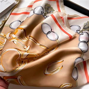 Detailed view of champagne satin scarf with equestrian patterns and horse buckles