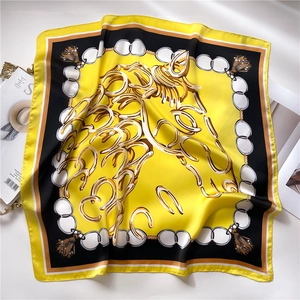 Detail of silk square scarf featuring yellow equestrian patterns of horses and chains