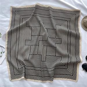 Close-up of lightweight square silk scarf featuring a black and white geometric stripe pattern