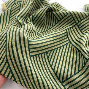 Close-up of lightweight green and yellow striped scarf with soft herringbone texture