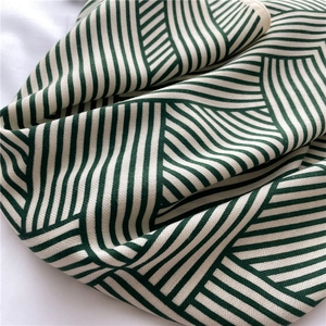 Close-up of deep green and cream geometric stripe pattern on twill woven fabric scarf