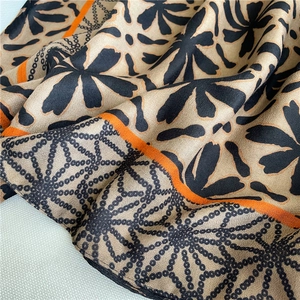 Close-up of bohemian floral cotton scarf with orange stripes and black polka dot details