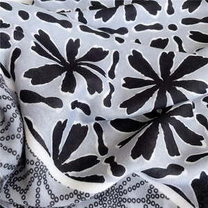 Macro detail of abstract floral print and polka dot texture on soft blue-grey scarf