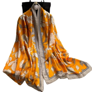 Écharpe châle longue orange vif avec imprimés floraux blancs et bordures grises