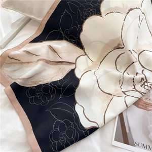 Detailed close-up of a large camellia floral print silk scarf with contrast pink borders